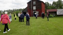 Pateniemi-Seuran ja Pateniemen Eläkeläisten retkeläisiä Vaalan Lamminahon Talolla harvinaisen kolmikerroksisen vilja-aitan äärellä. Oikealla holvattu kivikellari.